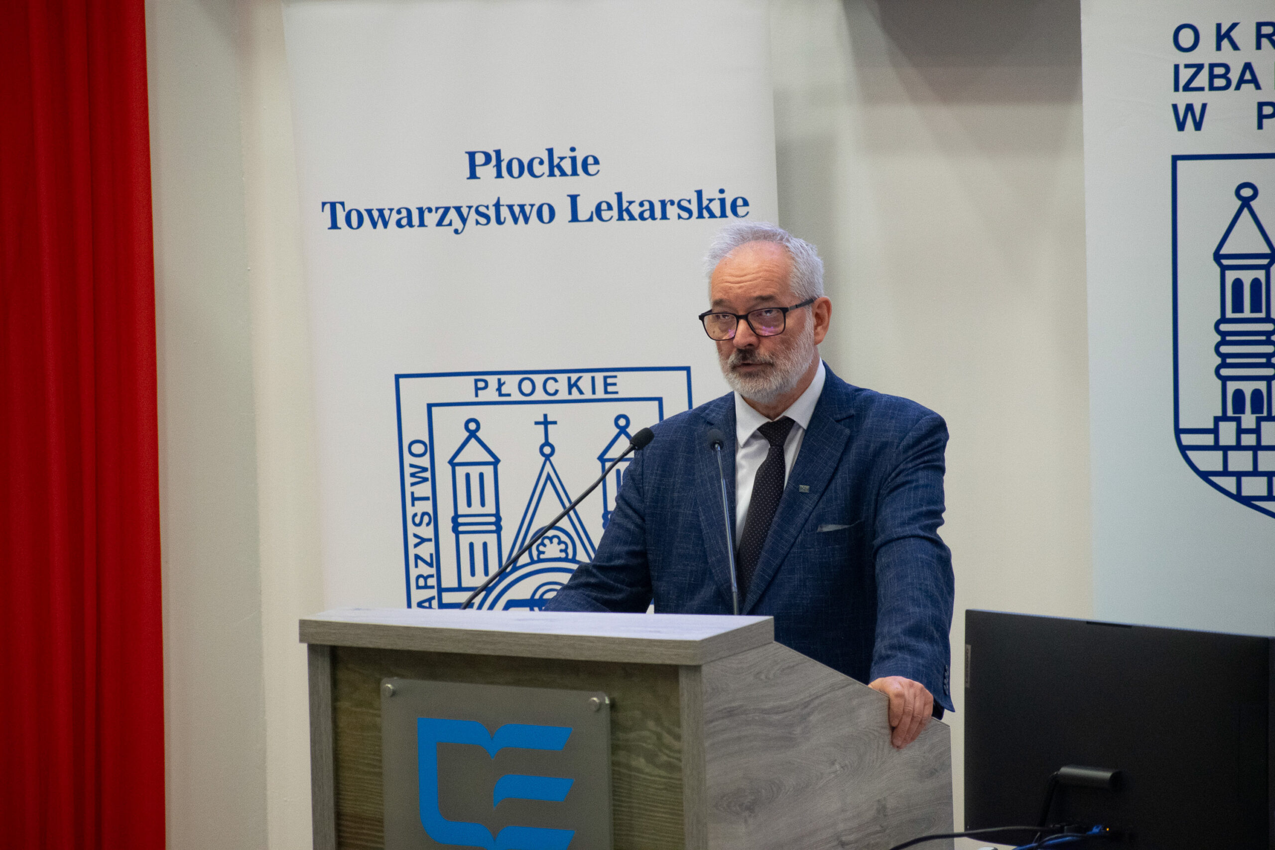 mężczyzna wygłaszający przemówienie przy ambonie do mikrofonów